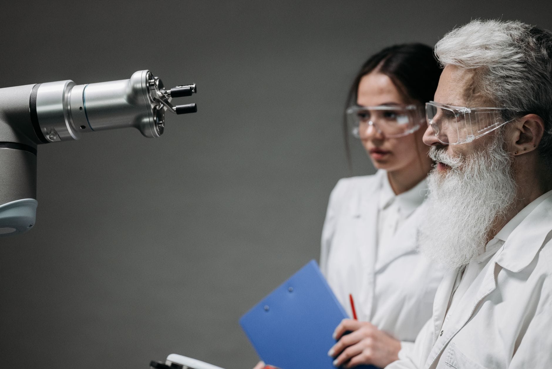 Dwóch naukowców w labie analizuje ramię robota w kontekście pracy zespołowej