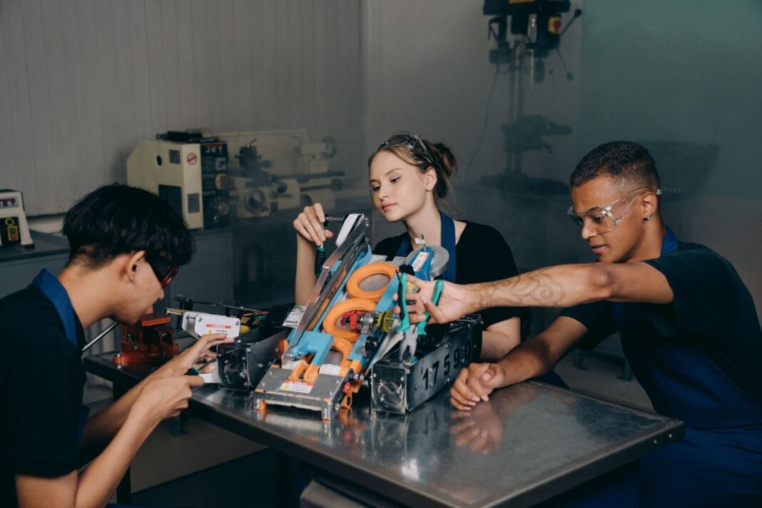 Studenci składający robota w laboratorium podczas pracy projektowej