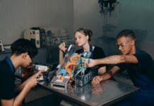 Studenci składający robota w laboratorium podczas pracy projektowej