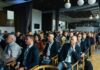 Punkty edukacyjne dla fizjoterapeutów za udział w konferencjach – ile można zdobyć i jak je rozliczyć? Uczestnicy konferencji branżowej słuchający prezentacji w sali